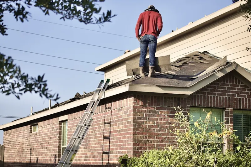 Professional roofer working on a residential roof in West Ridge